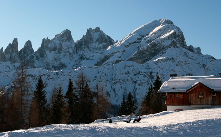 Baite cariche di neve e sullo sfondo le Dolomiti.